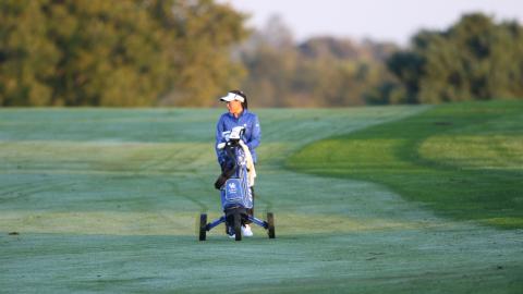 A UK women's golf team member walks on the turf at The University Club.